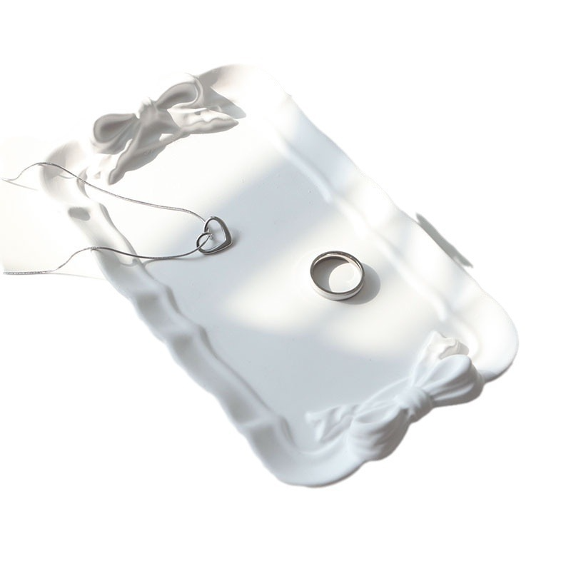 Rectangle white plaster tray with raised edges and sculpted bow details